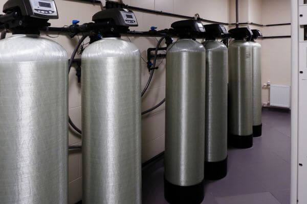 Water softeners are lined up a row against a wall