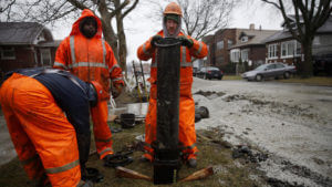 Men work on outdated infrastructure. Image courtesy of Chicago Tribune.