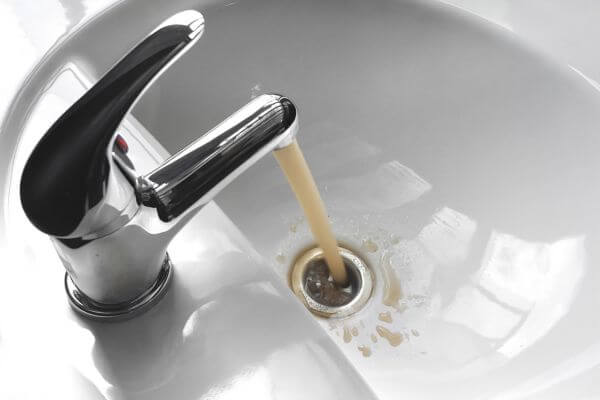 Dirty water flows from a bathroom faucet