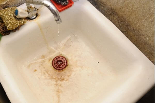 Rusty brown iron bacteria stains in sink
