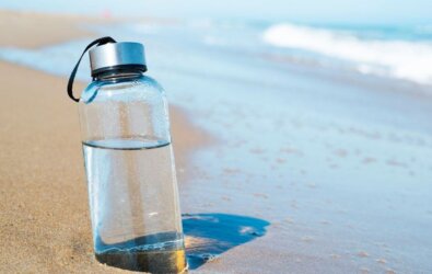 A reusable water bottle on a beach
