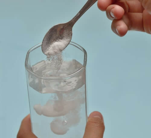 Photo of baking soda being mixed into water as an alkalinizing water treatment.