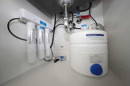 Picture of a Reverse Osmosis Water Filter installed beneath a kitchen sink.