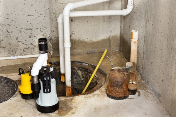 Image of an old sump pump being replaced by a new one.