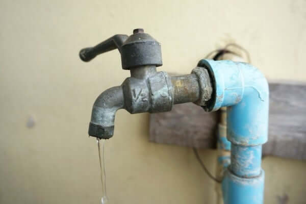 Image of a lead faucet with contaminated water dripping out of it