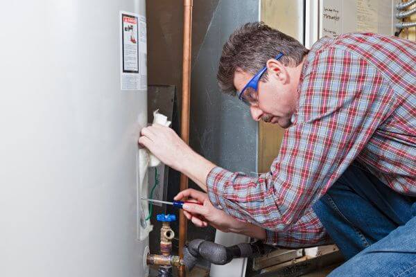 Image of man fixing water heater