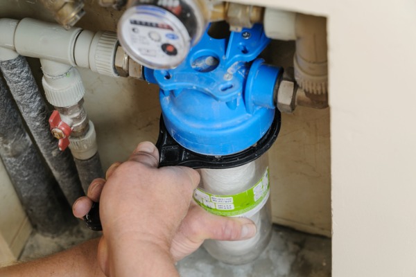 Image of a person’s hands working on a water filtration system.