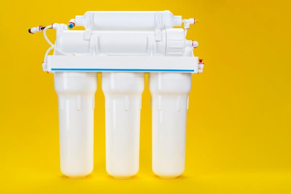 Image of a white reverse osmosis water filter on a yellow background