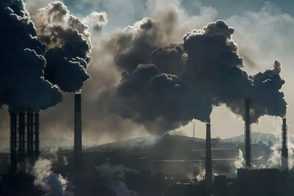 An image of smoke stacks blasting smoke into the air, which contains toxins that impact Chicago’s drinking water.
