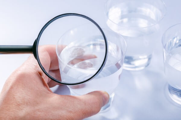 Image of a glass of water magnified by a magnifying glass.