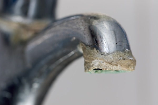 Image of a faucet with stains on it left by hard water