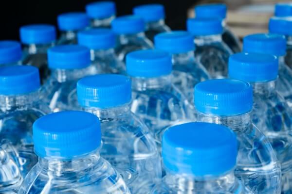 Image plastic bottles of water with blue lids