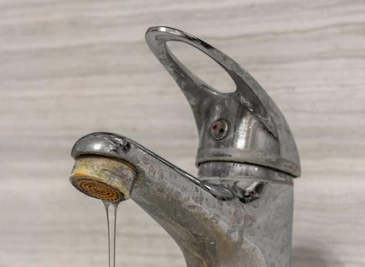 Image of a faucet with stains on it left by hard water