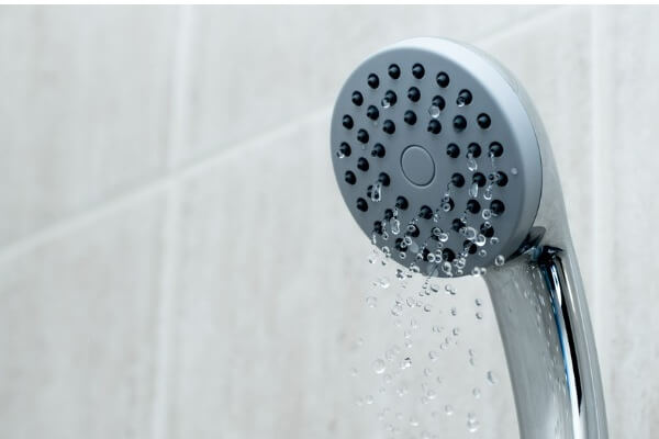 A shower head has low water pressure because of the Dixmoor water crisis