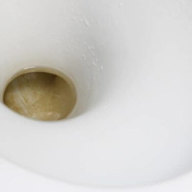 Brown toilet bowl stains in a toilet