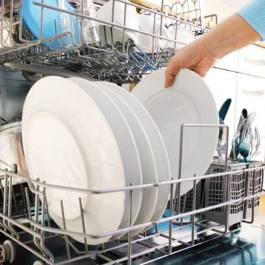Person removing cloudy dishes from the dishwasher