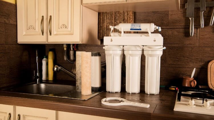 An under the sink reverse osmosis system next to the faucet
