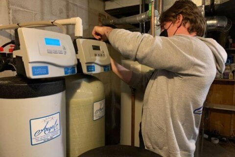Licensed plumber installing a whole house water filter for metallic taste
