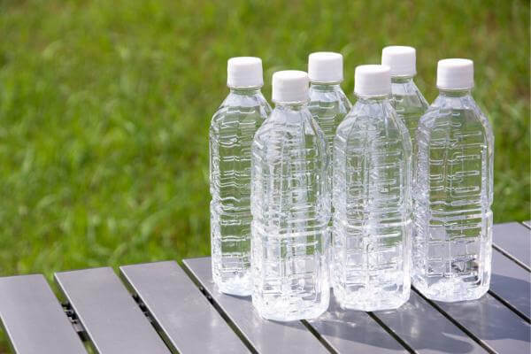 Several plastic bottles on a bench