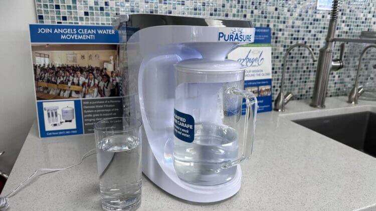 Countertop reverse osmosis system next to a glass of pure water