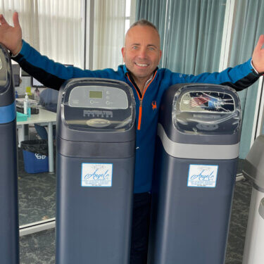 Andrew Wilson of Angel Water standing by water softener systems