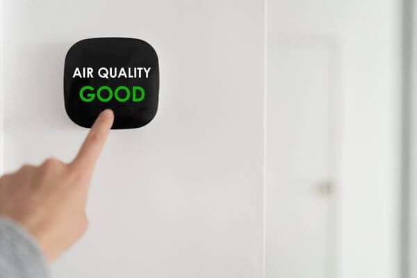 Hand pointing to a screen with a good air quality reading