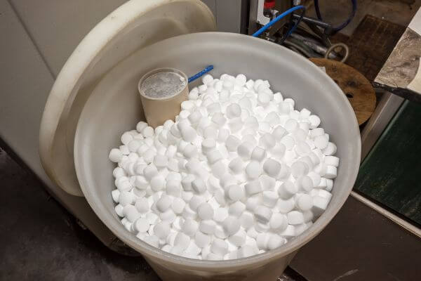 A bin of water softener salt with a scoop