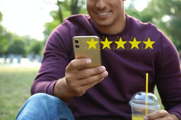 Five yellow stars appear in front of a man on his phone